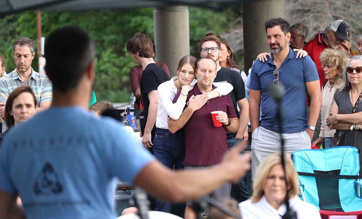 People listen to Adam Schluter during the Monday Night Dinner at McEuen Park.