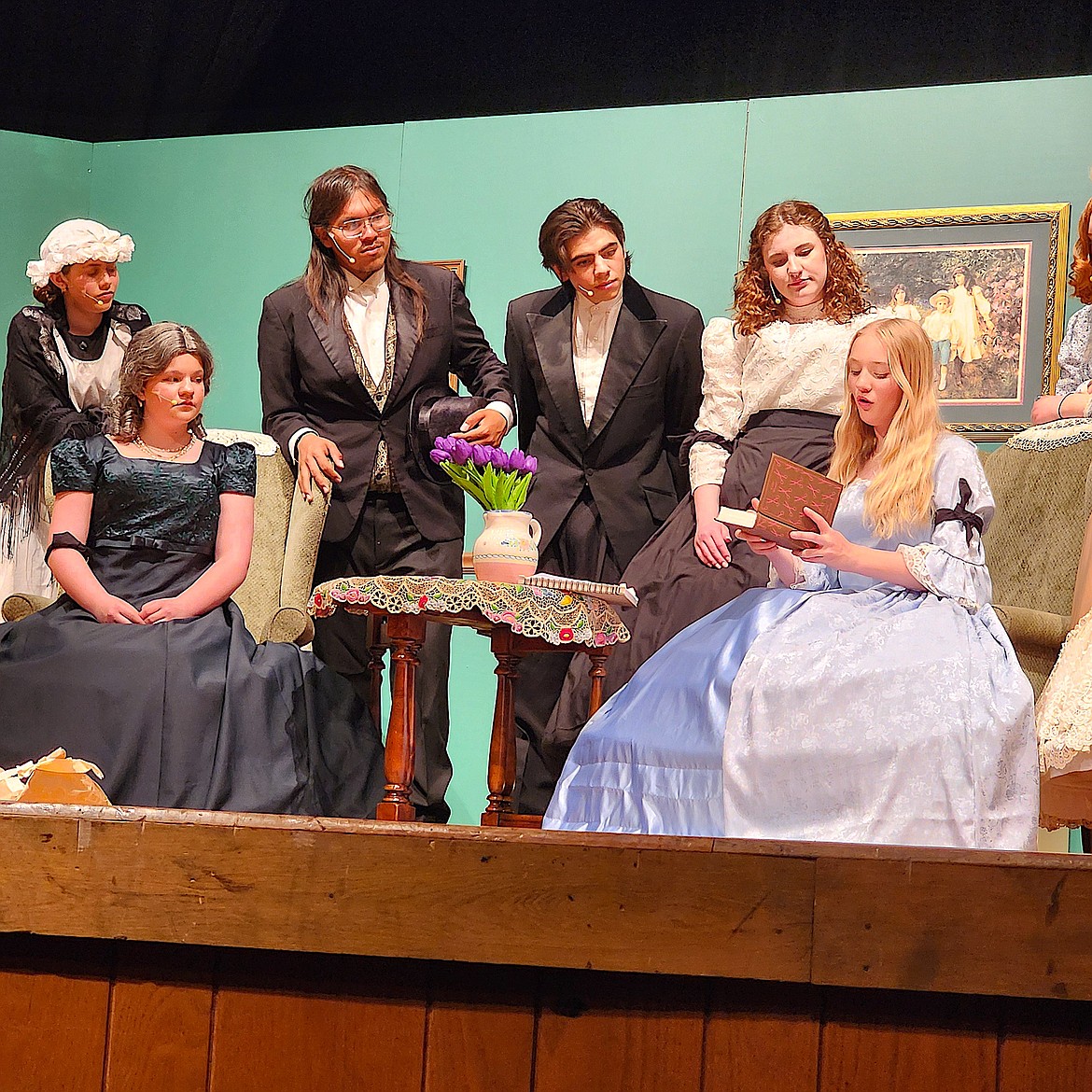 Aunt March, left, Hannah, Mr. Brooks, Laurie Lawrence and Marmee watch as Jo March unwraps her first novel. They are all actors in the Polson High School Theatre department's production of "Little Women." (Berl Tiskus/Leader)