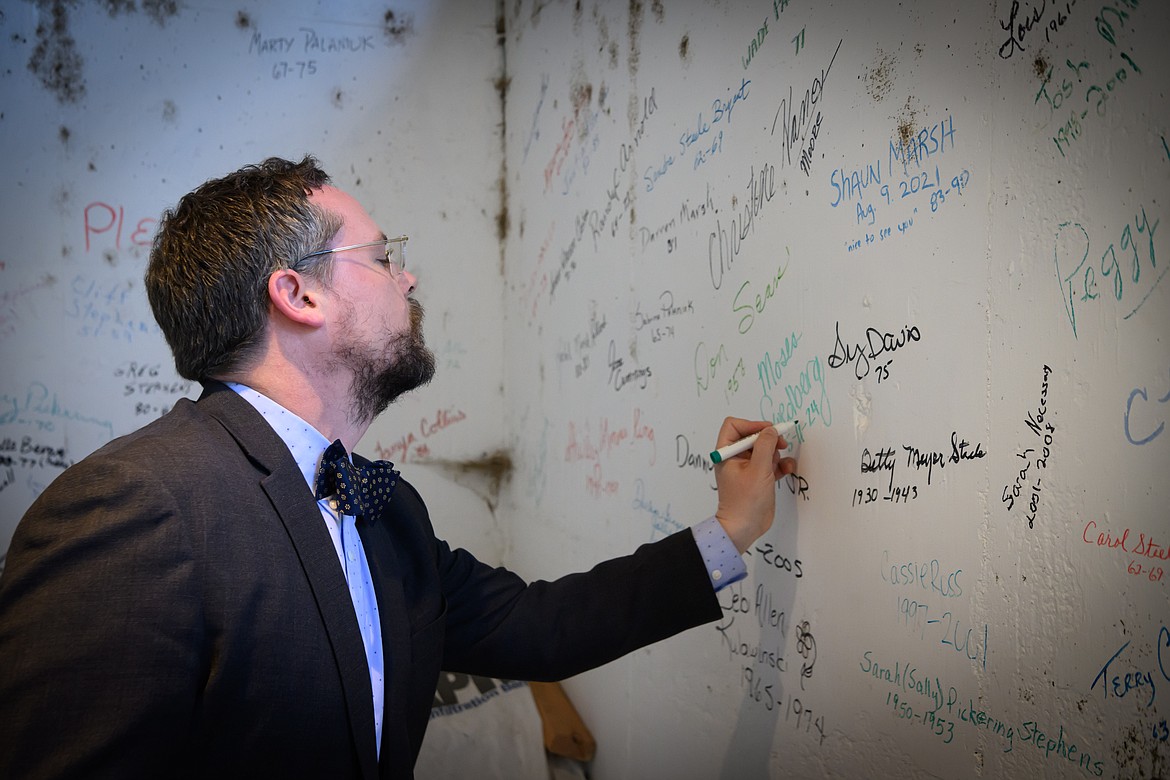 Moses Swedberg signs the Paradise School alumni wall. (Tracy Scott/Valley Press)