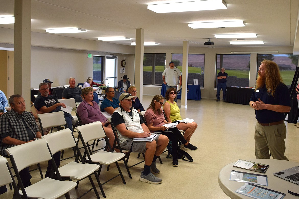 Desert Aire community members listen to Washington Department of Natural Resources Community Resilience Coordinator Jake Hardt prior to asking questions regarding wildfire protection in Desert Aire Wednesday afternoon.