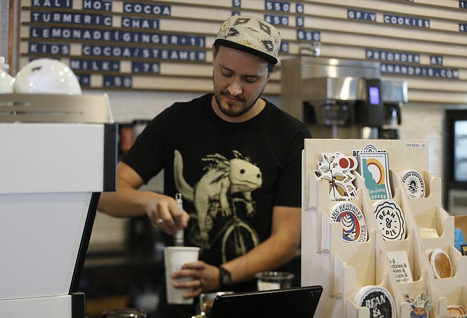 David Hawley, cafe manager for Evans Brothers Coffee’s downtown Coeur d’Alene cafe, prepares a drink for a customer.
