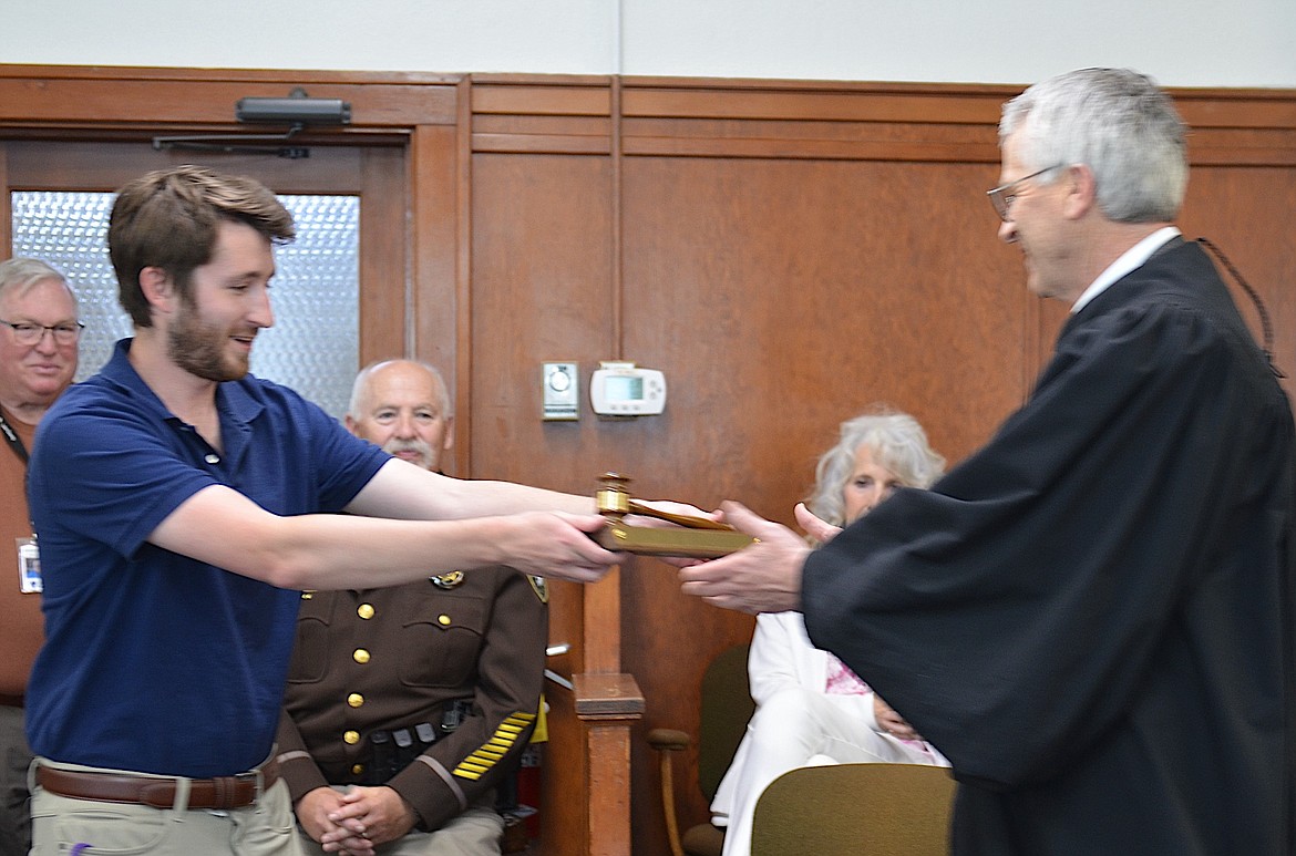 John Mercer's son, Mike, handed his dad an honorary gavel Monday, in honor of Judge Mercer's appointment to the 20th Judicial District Court. (Kristi Niemeyer/Leader)
