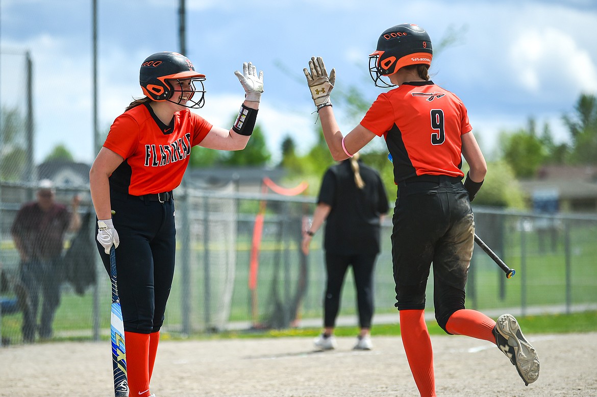 Flathead's Kinsey Lake (9) gets a high-five from teammate Olivia Nyman (16) after Lake scored the tying run in the bottom of the seventh against Butte at  Kidsports Complex on Tuesday, May 14. (Casey Kreider/Daily Inter Lake)