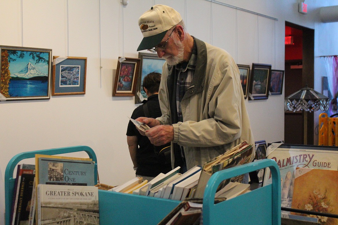 A shopper examines a postcard at the Rusty Mammoth sale.