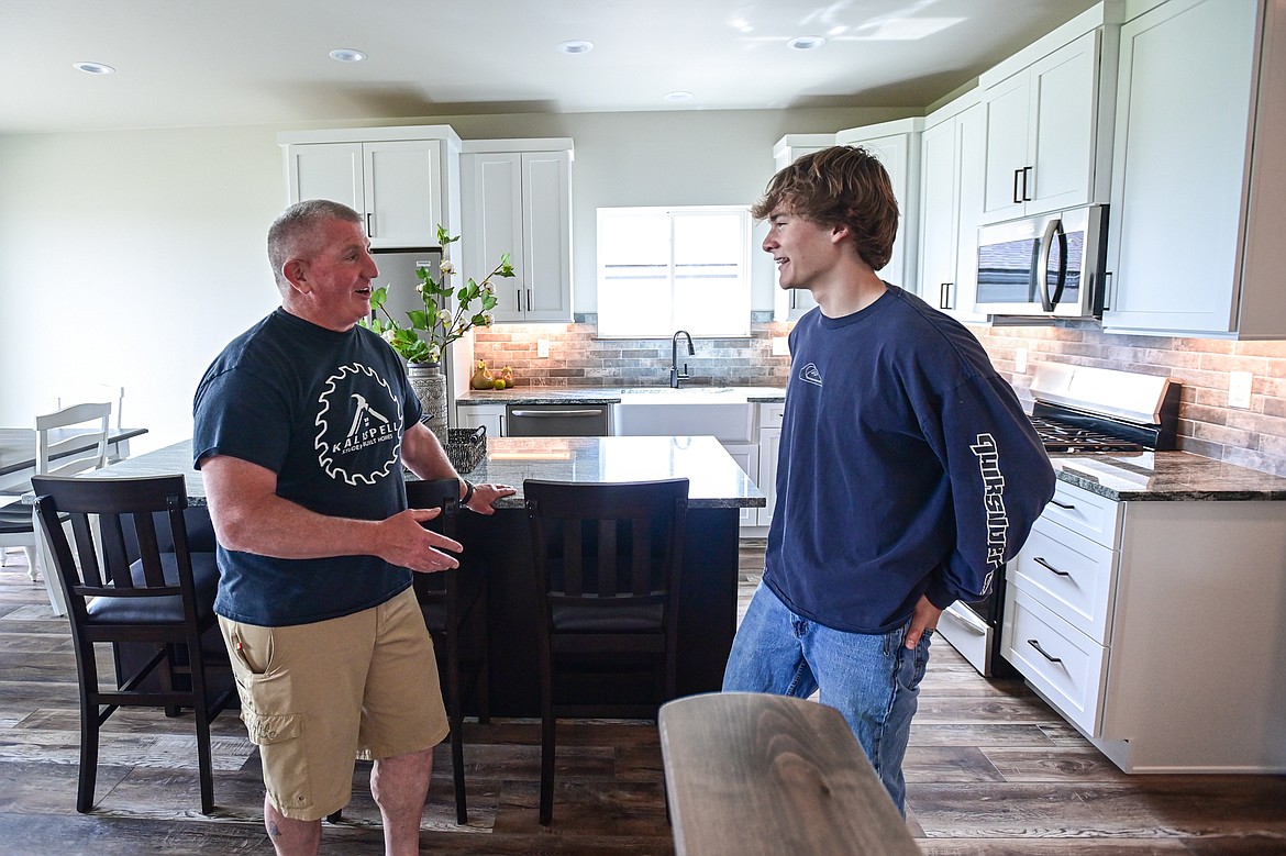 Brock Anderson, lead instructor with the Student Built Homes program at Kalispell Public Schools, speaks with Clayton Peterson, a junior at Flathead High School, during an open house to showcase the program's latest finished home at 225 Northridge Way in Kalispell on Wednesday, May 15. (Casey Kreider/Daily Inter Lake)