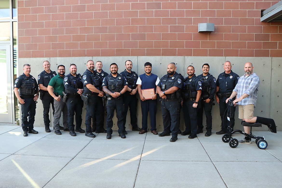 Moses Lake resident Branli Arroyo, center, poses with Moses Lake Police officers and shows his Citizen Service Award, which he received at Tuesday’s Moses Lake City Council meeting. Arroyo received the award in recognition of the assistance he rendered to an officer making an arrest in March.