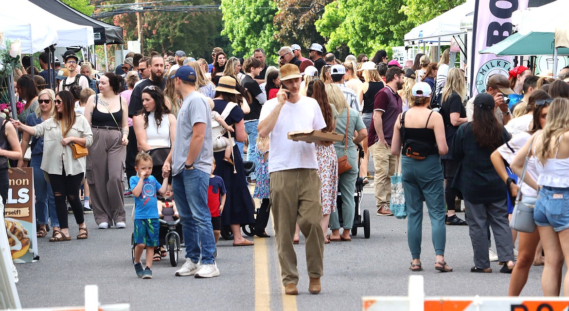 Tanden Launder chats on the phone amidst the rush of the crowd at the Fifth Street Farmers Market on Wednesday.