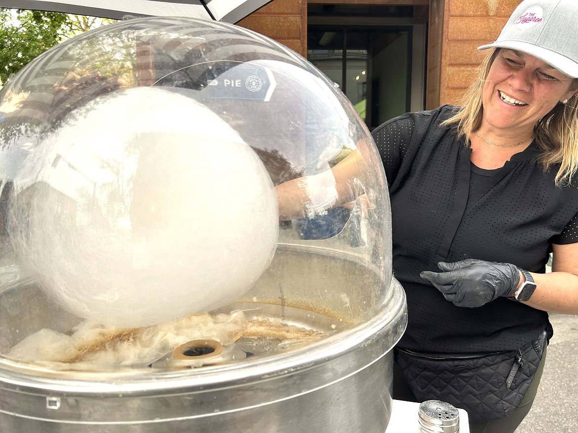 Rebecca Paliotto, owner of The Sugaree, whips up cotton candy at the farmers market on Wednesday.