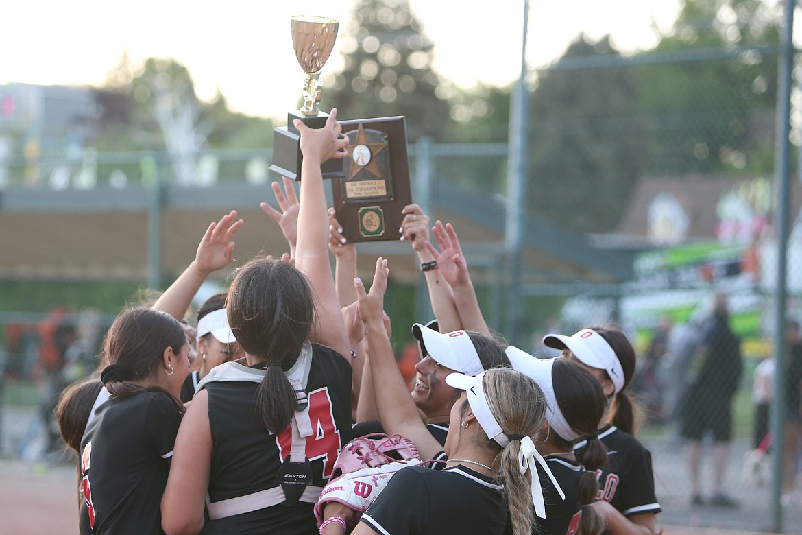 Othello players celebrate with the Central Washington Athletic Conference district championship trophy after defeating Ephrata 12-5 on Tuesday in Selah.