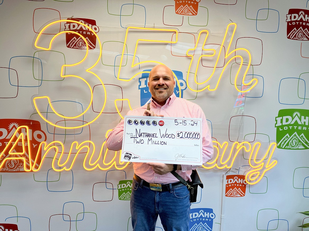 Nathan Wood poses a big check to commemorate his winning $2 million in the Powerball lottery drawing after his ticket matched the first five numbers.