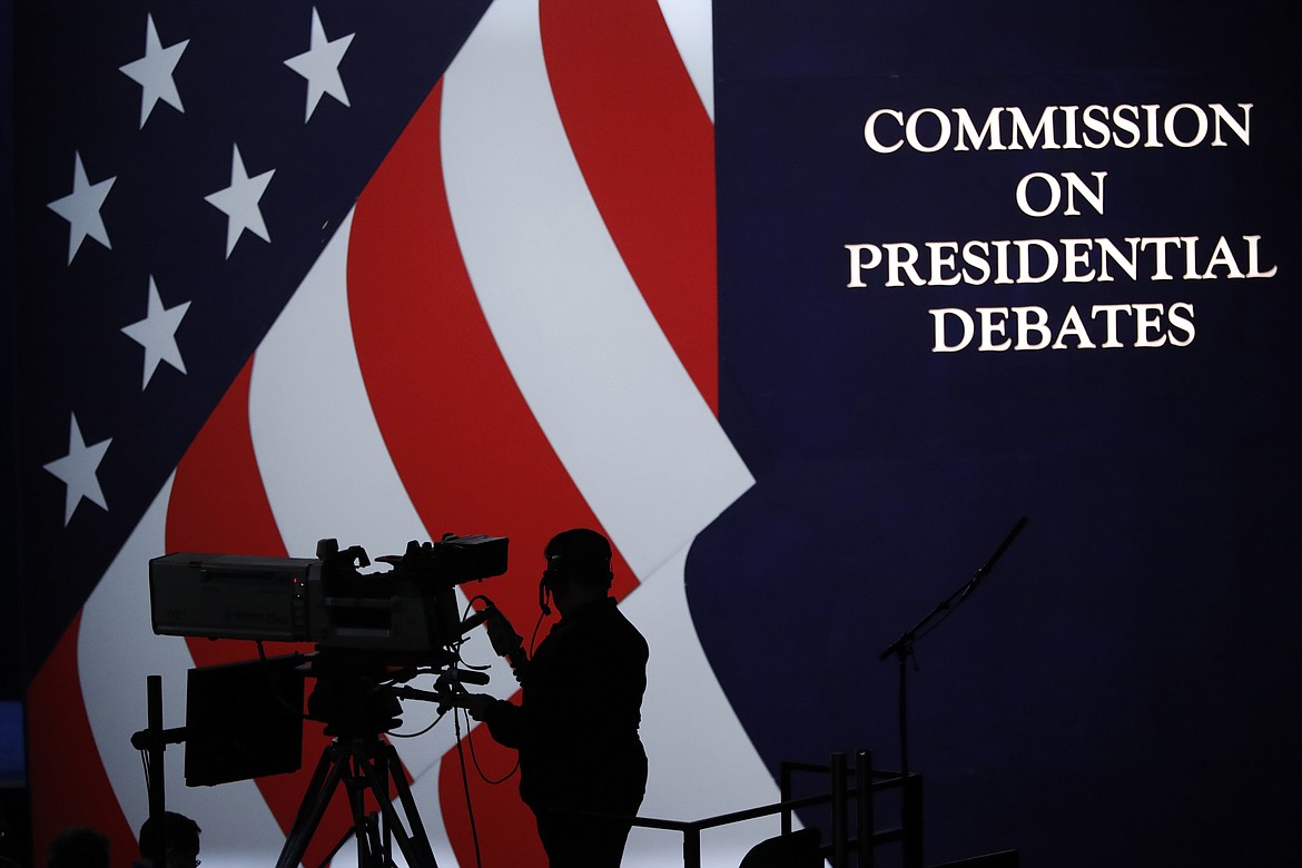 A cameraman is silhouetted against an an American flag during preparations for the presidential debate at Hofstra University in Hempstead, N.Y., Sept. 25, 2016. The nonpartisan Commission on Presidential Debates, which has planned presidential faceoffs in every election since 1988, has an uncertain future after President Joe Biden and former President Donald Trump struck an agreement to meet on their own. (AP Photo/Mary Altaffer, File)