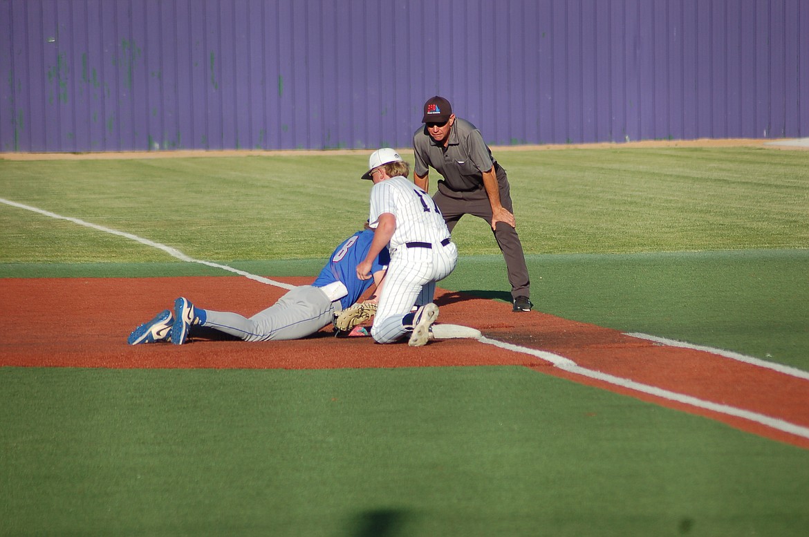 Photo by CANDICE SMITH
Lake City first baseman Charlie Dixon applies the tag as Bam Fenter returns to first on a pickoff attempt Thursday in the first round of the state 5A baseball tournament in Caldwell.