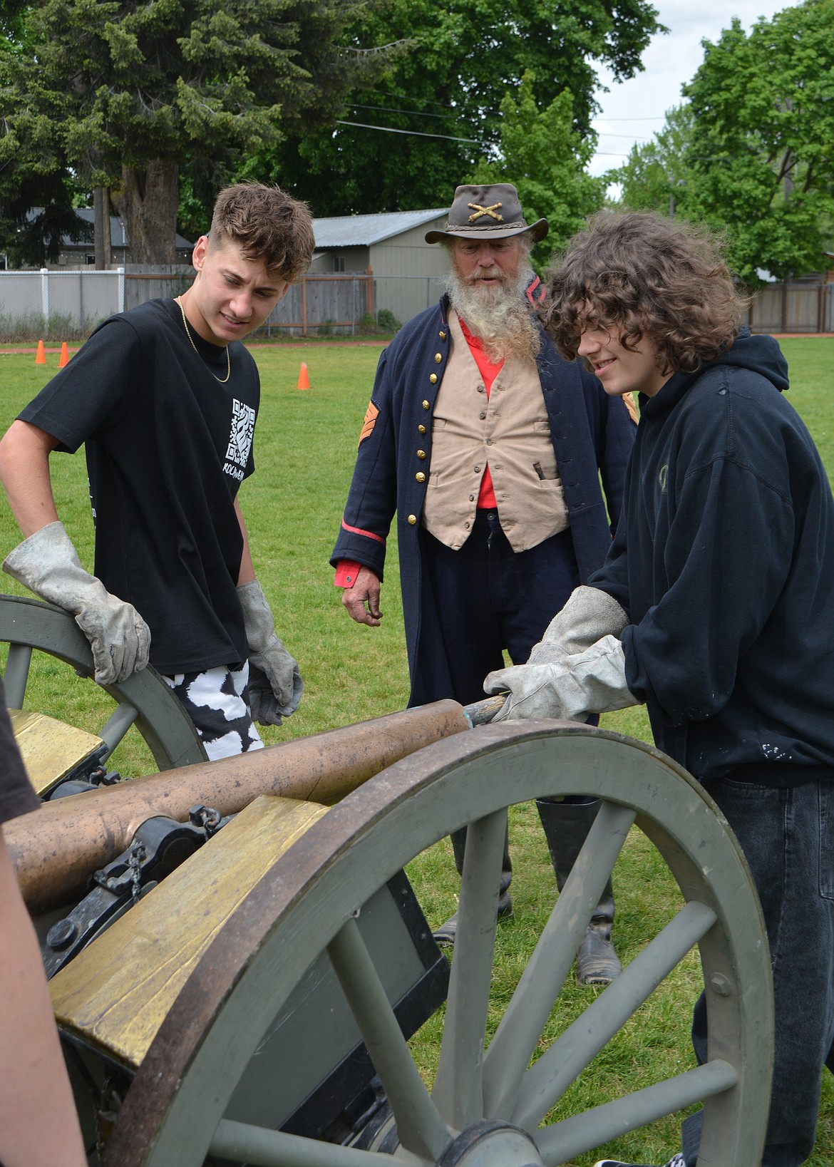 Gage Marmon pushes in a ramrod into the barrel of a cannon under the supervision of Civil War reenactor Gene Black.