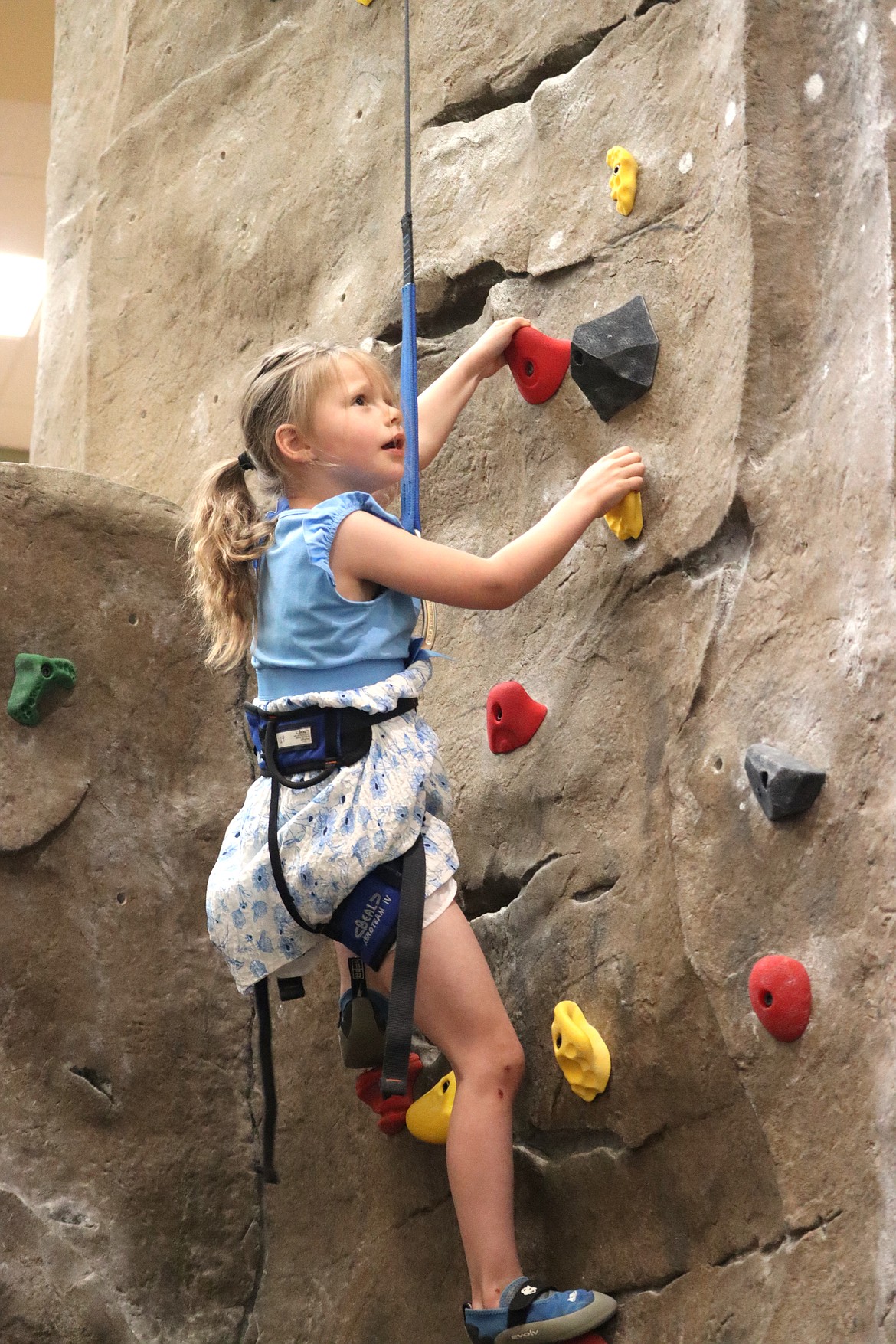 Sarah Rains tries the climbing wall at the Kroc Center during its recent open house to celebrate its 15th anniversary.