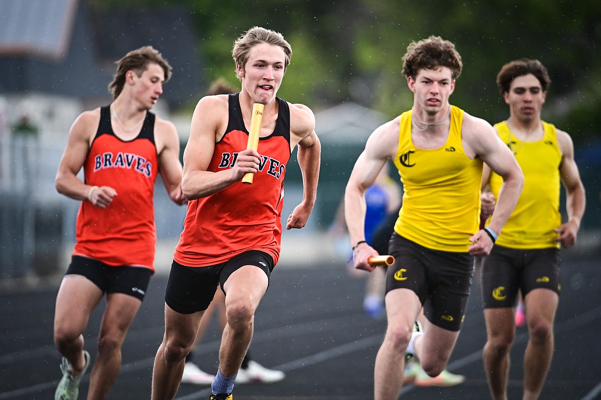 Flathead's Will Hollensteiner takes the baton from Ben Bliven to run the anchor leg of the boys 4x400 relay for a first place finish with a time of 3:21.66 with teammates Lane Chivers and Kasen Kastner at the Western AA Divisionals at Legends Stadium on Saturday, May 18. (Casey Kreider/Daily Inter Lake)