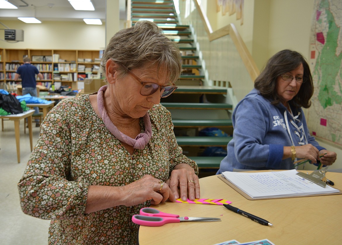 Shelli Niemi and Denise Bausch work on kits for seniors and homelessness hygiene kits at Kellogg Public Library through a program offered through the AmeriCorps 9/11 grant.