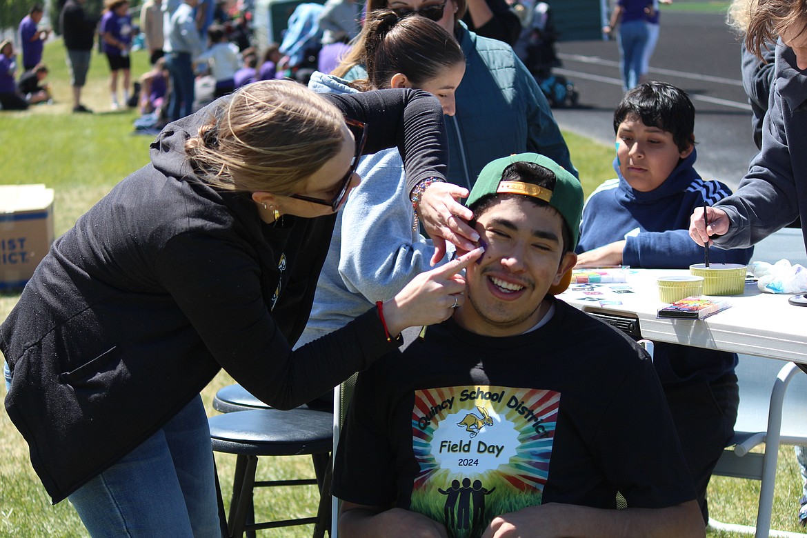 A participant gets his face painted at Field Day.