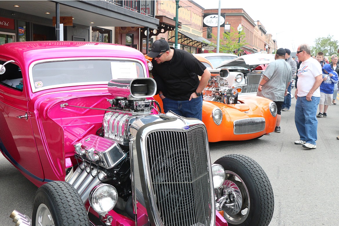 Troy Rimstad peeks into the interior of his 1934 hot pink three-window Ford coupe street hot rod.