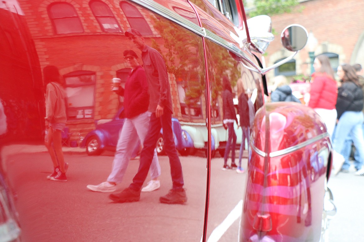 Classic car fans are reflected in the highly polished paint of one of hundreds of cars that filled the downtown during Saturday's Lost in the '50s classic car show.