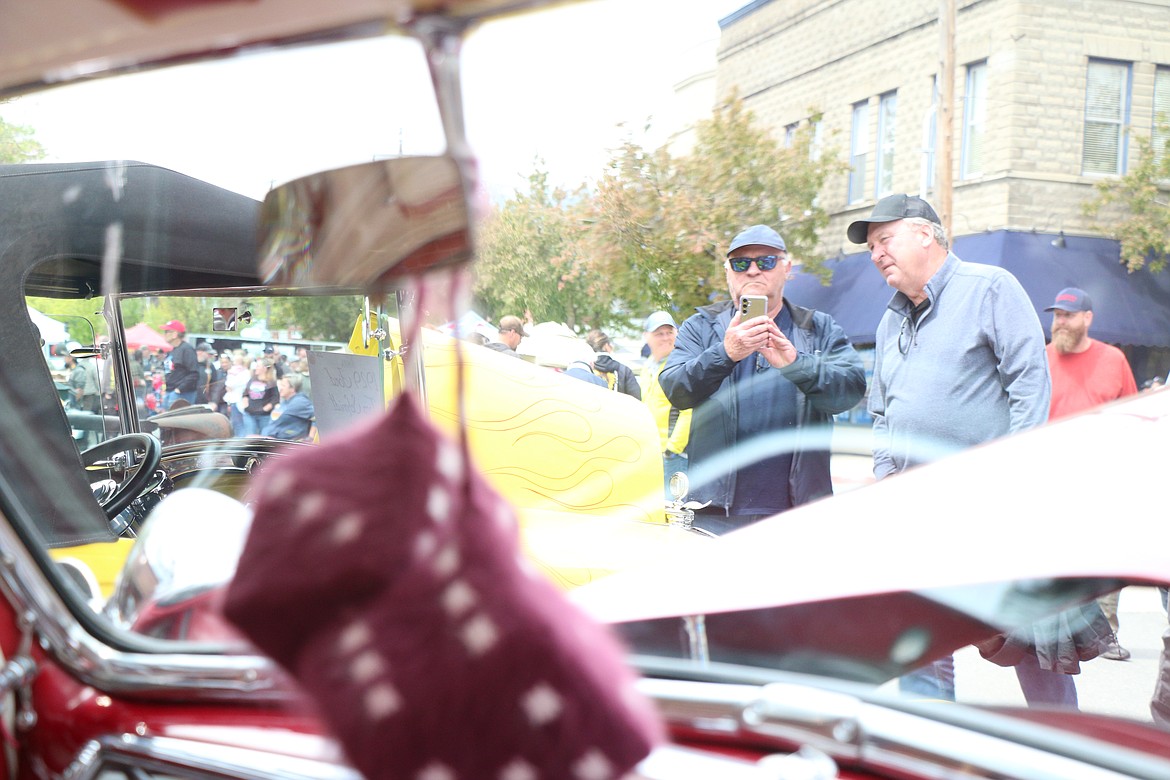 Classic car fans take a photo of a car during Saturday Lost in the '50s car show.