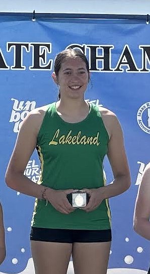 Courtesy photo 
Lakeland High senior Ziya Munyer, center, stands with her medal on the podium after winning her second straight state 4A triple jump title on Saturday at Mountain View High in Meridian.