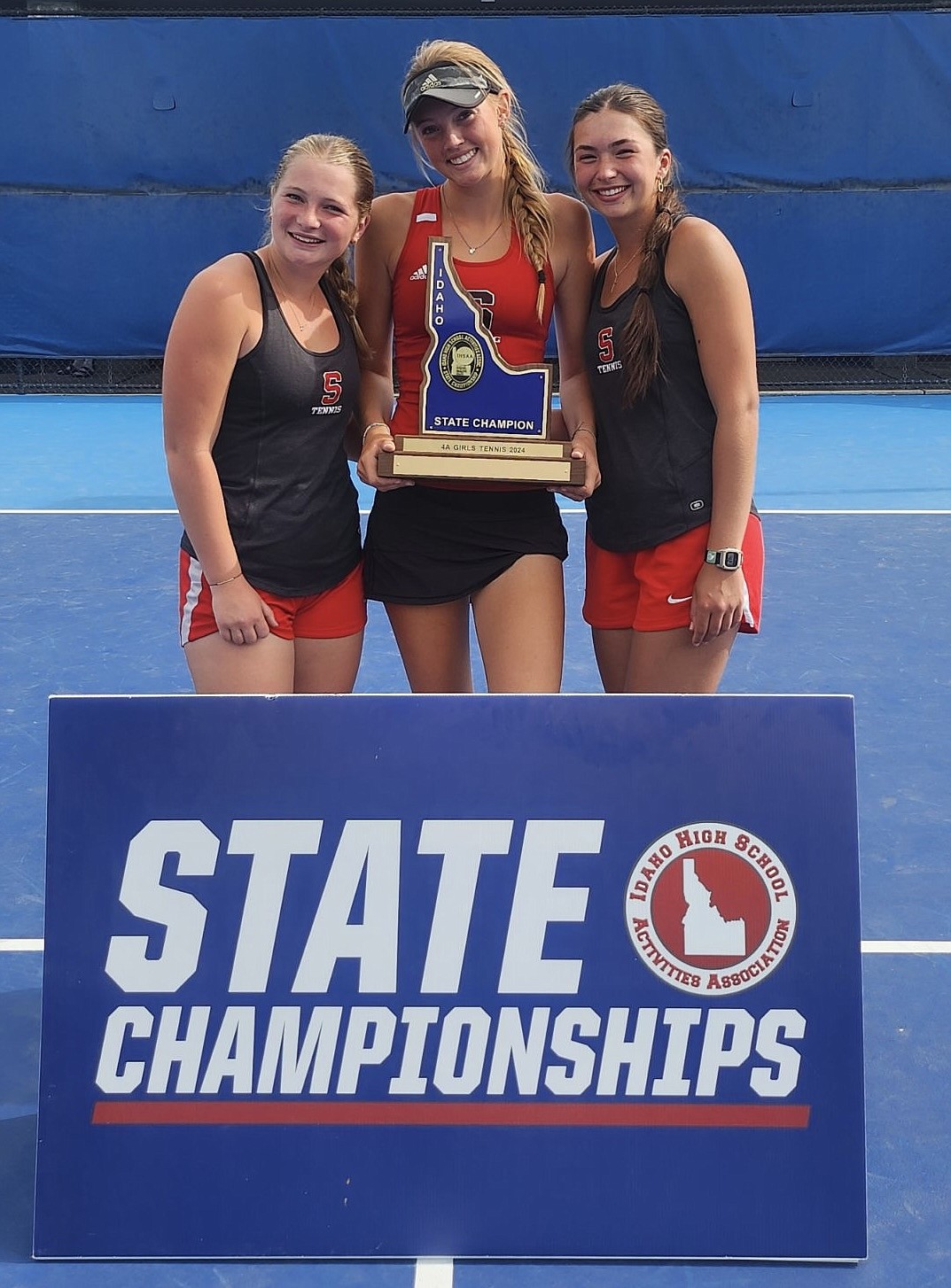 Courtesy photo
Sandpoint freshman Pepper Rickert, center, won in girls singles and the girls doubles team of Aubrey Knowles (left) and Sydney Webb (right) helped lead the Bulldogs to their first team title in program history on Saturday.