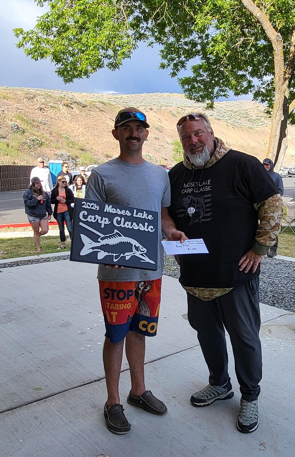 Austin Rosbrough, left, and Pedro Jimenez teamed up to catch the biggest fish at the 2024 Moses Lake Carp Classic. Ty Swartout, right, presented the award.