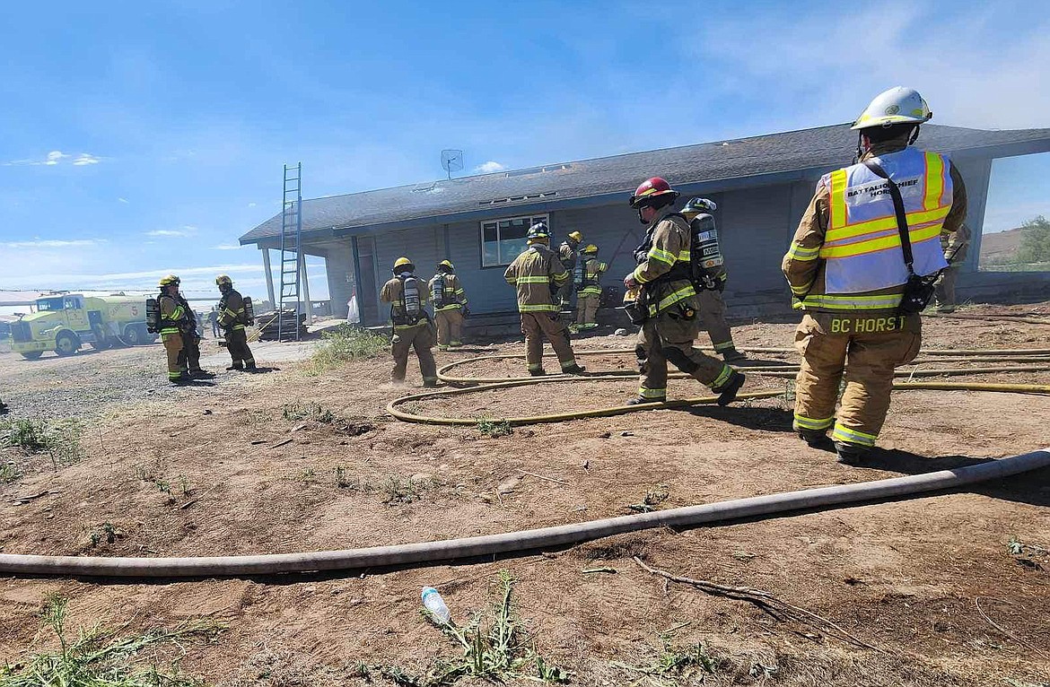 Firefighters from Grant County Fire District 5 prepare for training on an acquired structure on Road 10 Northeast near Moses Lake Saturday.