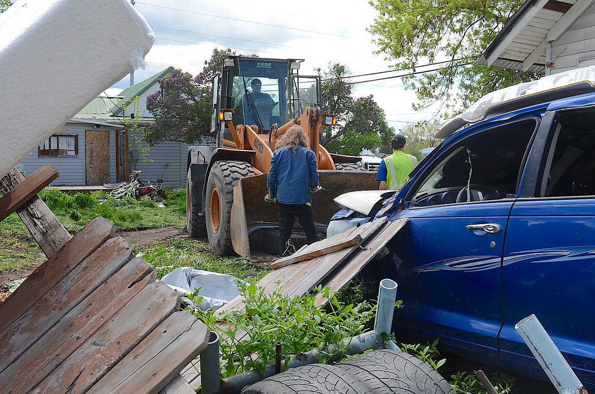 A crew of city employees spent much of Thursday removing an estimated 15 loads of garbage from the yard of a vacant house on 7th Ave. E. (Kristi Niemeyer/Leader)