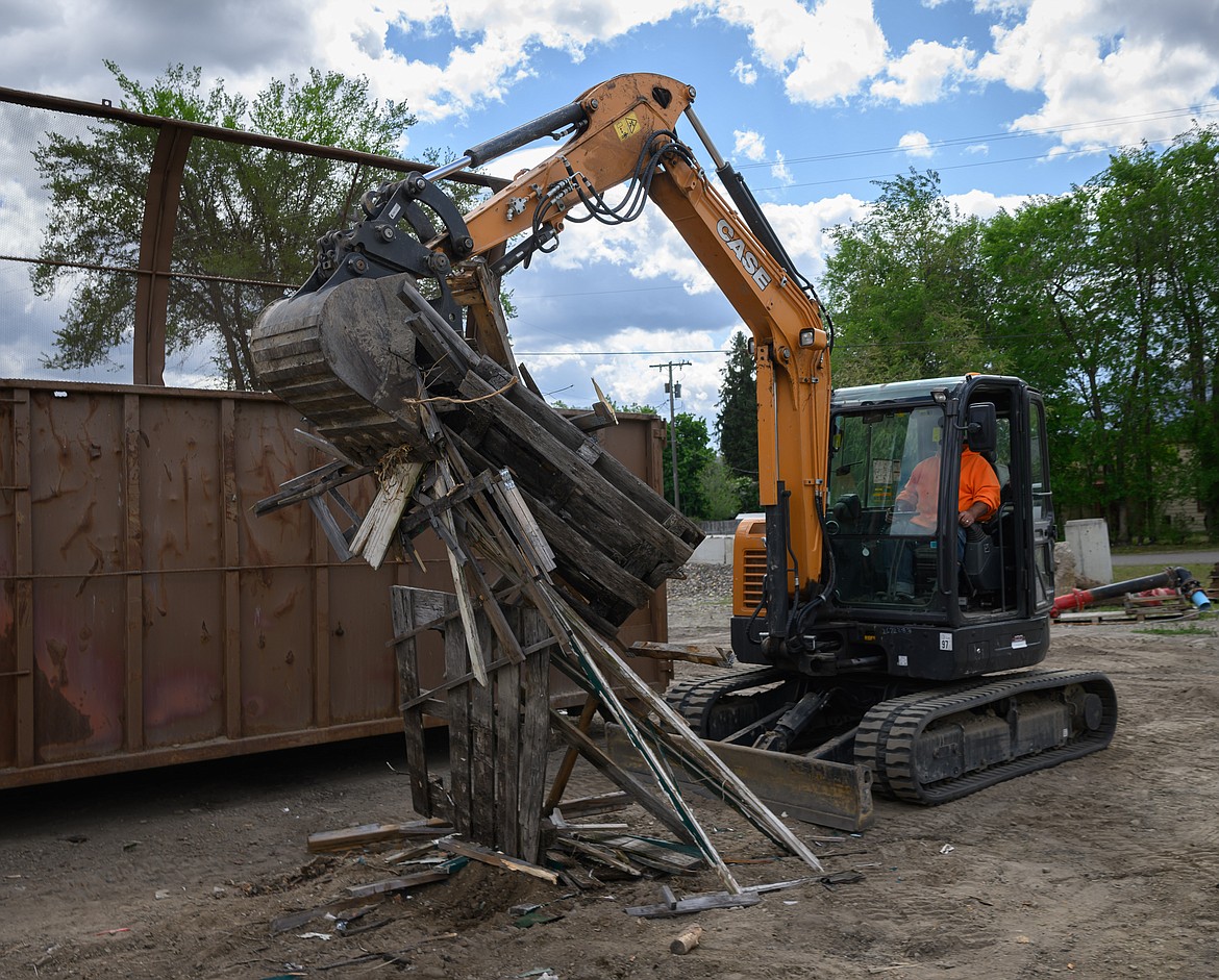 Plains employee Bruce Newton loads items into a dumpster. (Tracy Scott/Valley Press)