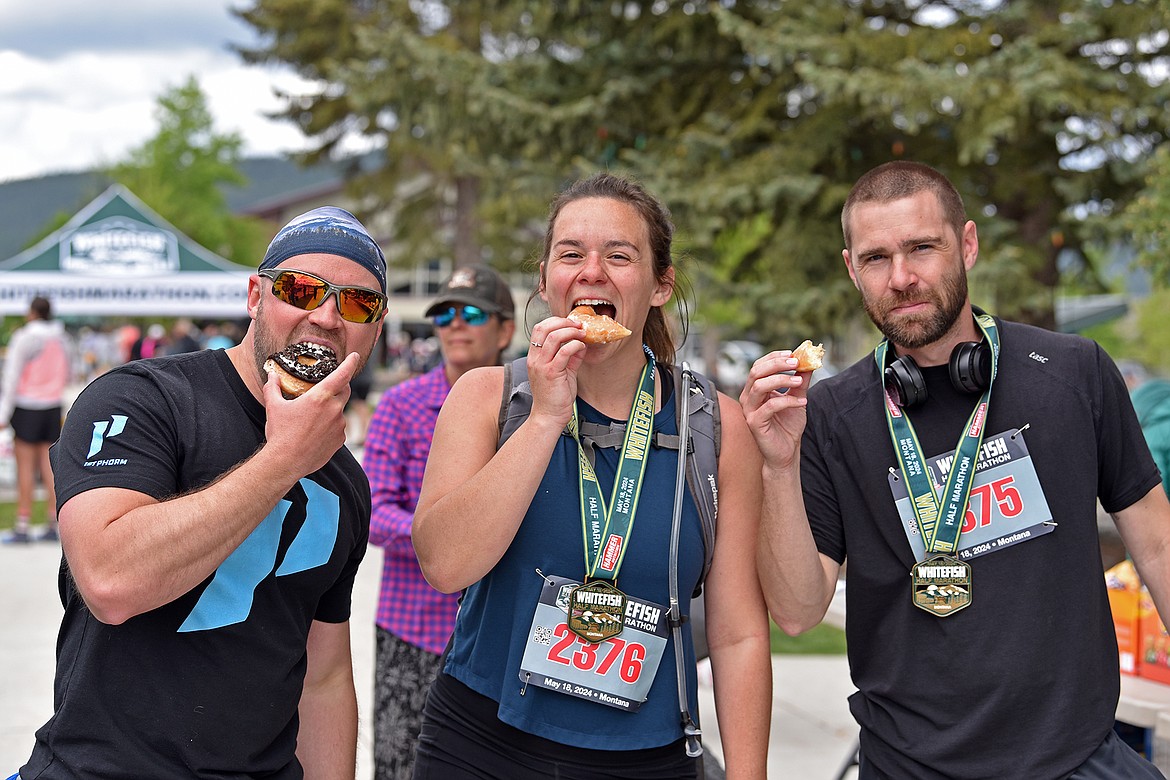 Three runners enjoy some post-race donuts at the Whitefish Marathon May 18, 2024. (Julie Engler/Whitefish Pilot)