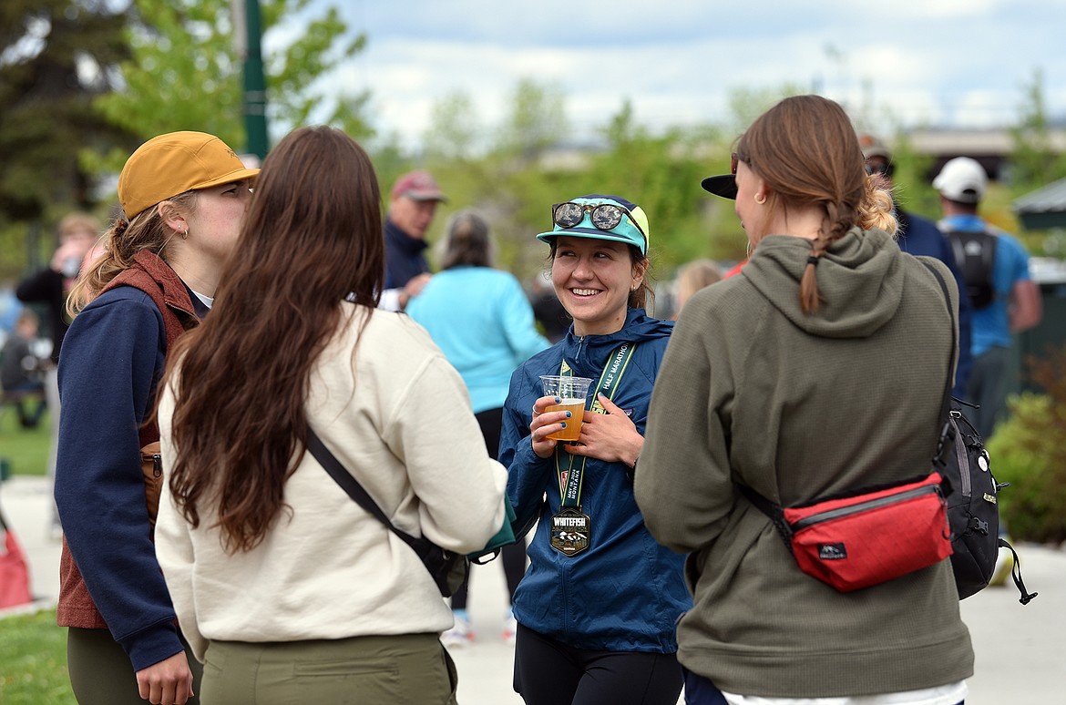 A runner enjoys a post-race beer with friends at the Whitefish Marathon. (Julie Engler/Whitefish Pilot)