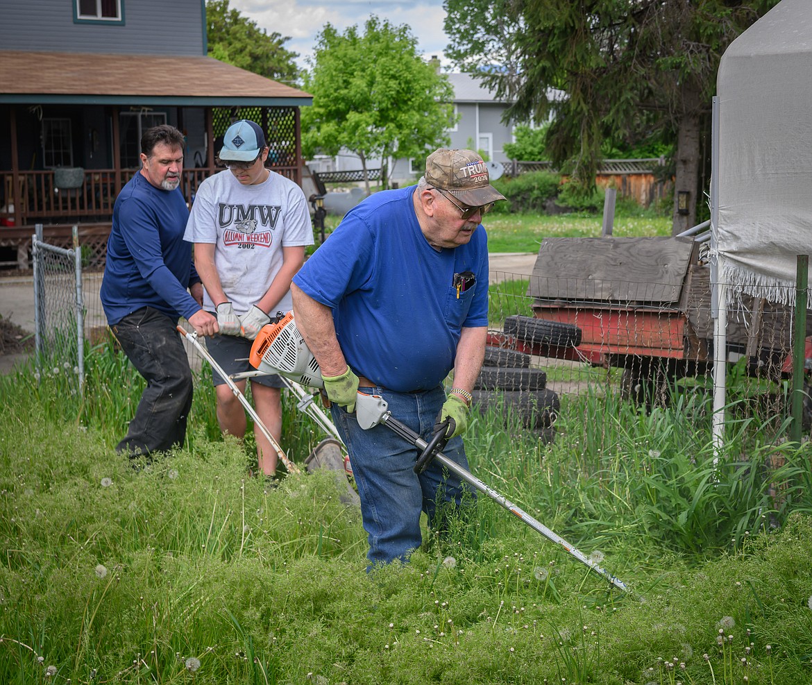 Bill Beck clears weeds with Scott Johnson and Lylan Bostick. (Tracy Scott/Valley Press)