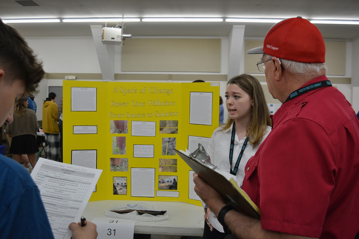 Lake Pend Oreille High School student Emma Hogan talks about her research and community outreach to Youth Water Summit judge Kelly Hanson. Her project focused contaminants on wooden power poles potentially impacting plant growth around them.