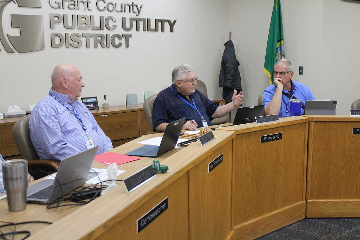 Grant County PUD commission chair Tom Flint, center, makes a statement during a PUD workshop Tuesday, while commissioners Terry Pyle, left, and Larry Schaapman, right, listen.