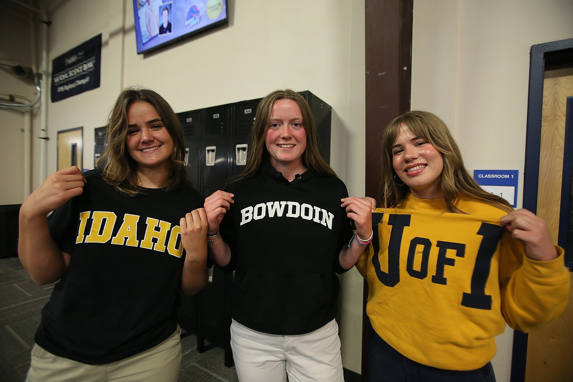 From left, high school seniors Jessalyn Adams, Alexa Sheppard and Emma Fisch show off their university sweatshirts Wednesday morning during signing day at Coeur d'Alene Charter Academy. Adams and Fisch will attend the University of Idaho in Moscow this fall while Sheppard will head to Bowdoin College in Brunswick, Maine.