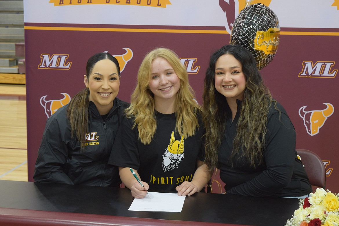 Moses Lake High School senior Kamaya Villegas sits with the Moses Lake drill team coaches during Villegas’s Wednesday afternoon signing to the University of Idaho’s Vandal Spirit Squad.