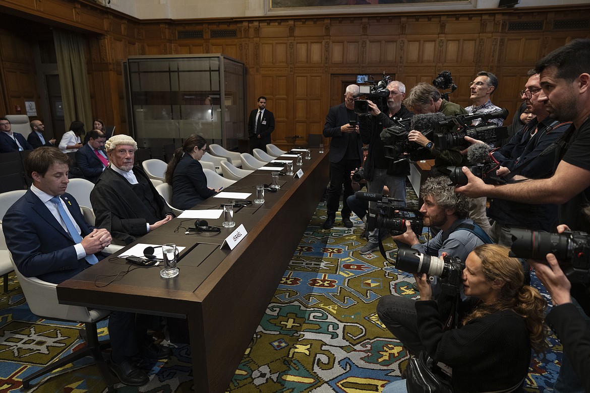 Journalists take images of Israel legal team before Judges enter the International Court of Justice, or World Court, in The Hague, Netherlands, Friday, May 24, 2024, where the top United Nations court ruled on an urgent plea by South Africa for judges to order Israel to halt its military operations in Gaza and withdraw from the enclave. (AP Photo/Peter Dejong)