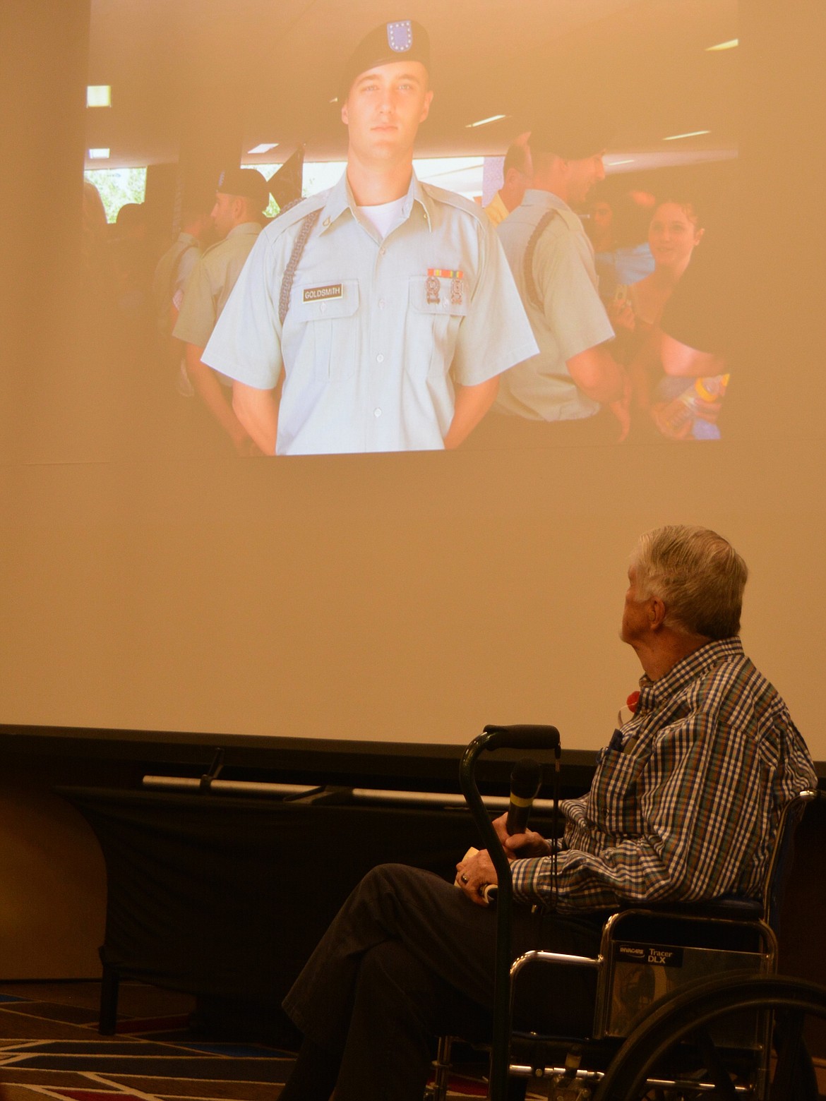John Goldsmith looks up at a photo of his son, Wyatt Goldsmith wearing his Green Beret regalia, during a slide show as part of a Memorial Day tribute honoring Gold Star families.