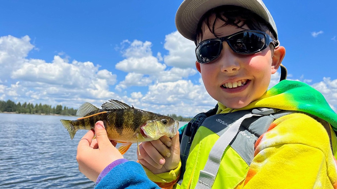 A youngster holds a tagged fish. Idaho Fish and Game fisheries biologists attach orange-colored “t-bar anchor tags” to various fish species throughout the state to learn more about them.