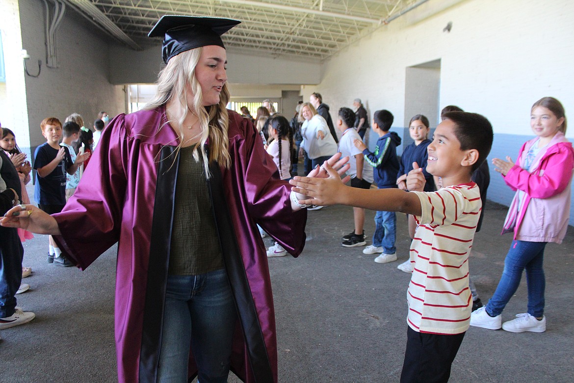 A Moses Lake High School senior - and Peninsula alumni - high-fives a current Peninsula student.