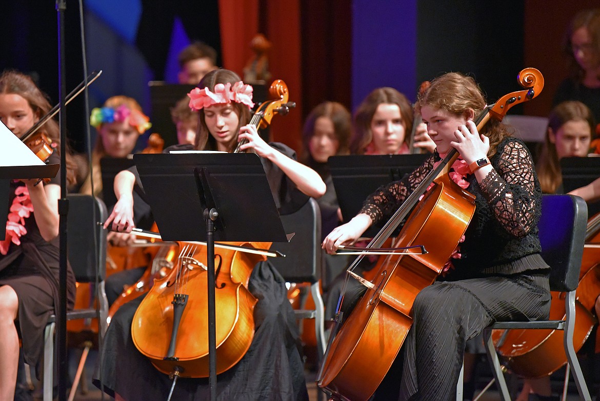 7th grade orchestra students adorn leis during a performance of a song from the Moana soundtrack. Pictured in focus are cellists Eleanor Parsons and Ada-Rose Petersen. (Kelsey Evans/Whitefish Pilot).