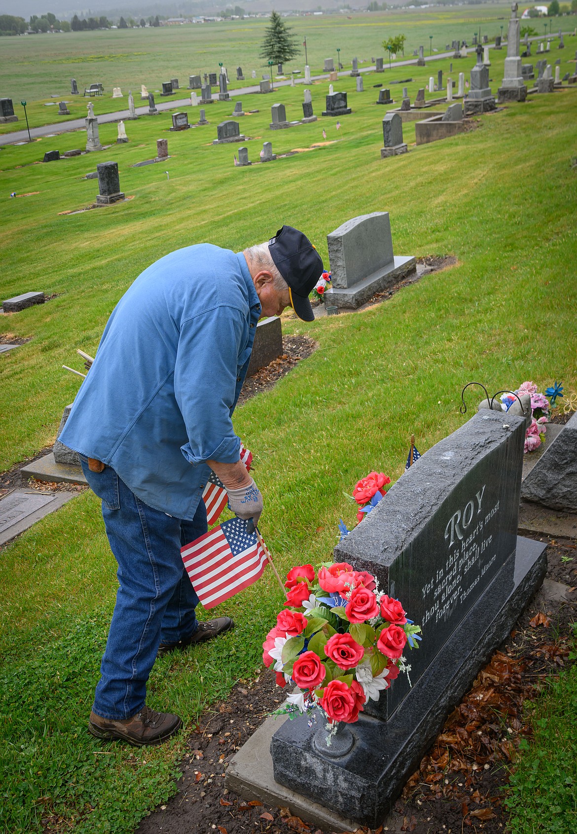 Bill Beck places American flags on veterans graves. (Tracy Scott/Valley Press)