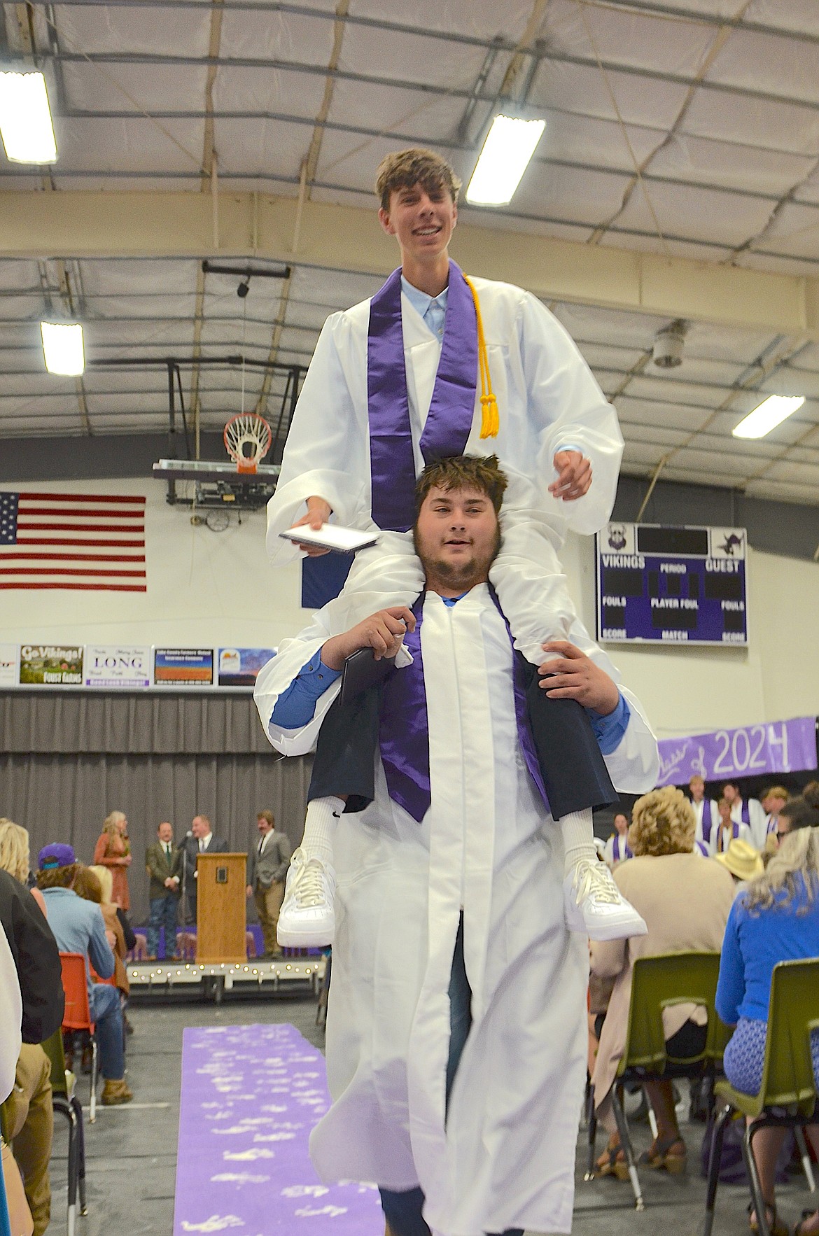 Exuberant graduates Hayden Smith on the shoulders of Titan Inman head for the exit following Charlo's graduation ceremony Sunday. (Kristi Niemeyer/Leader)