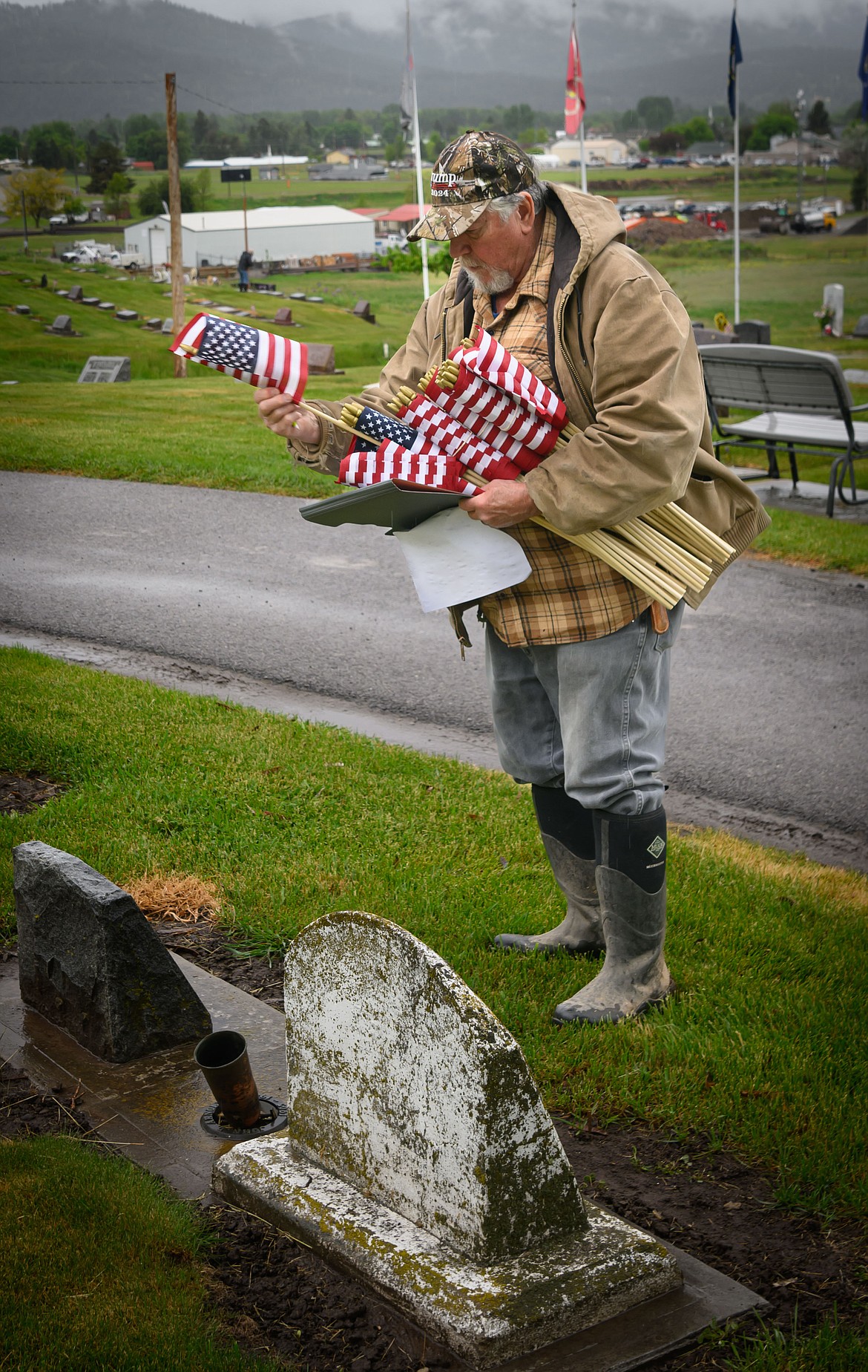 Army veteran Dan Johnson places flags at the Plains Cemetery. (Tracy Scott/Valley Press)