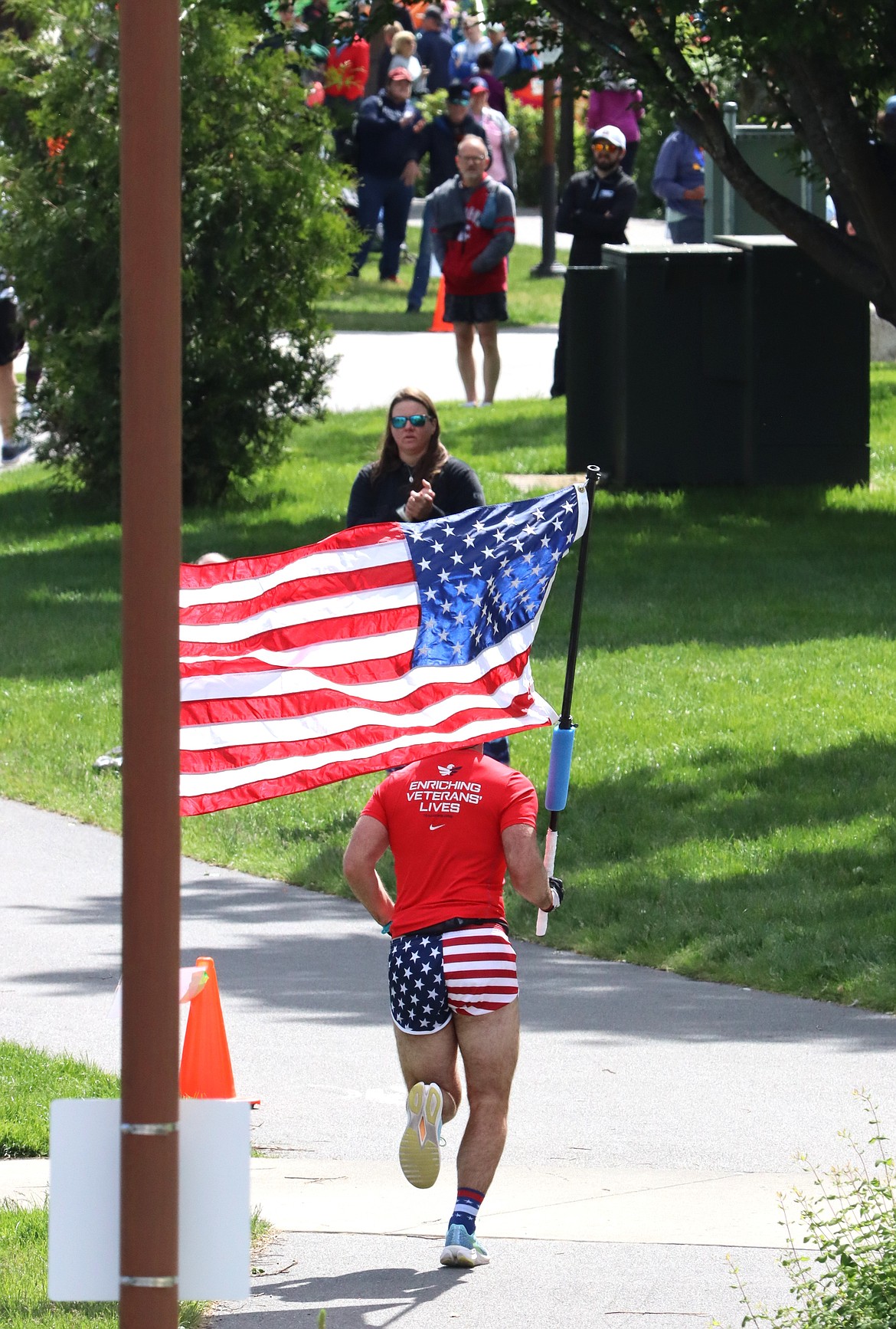 Craig Gulledge carries a flag as he heads toward the finish line of the Coeur d'Alene Marathon on Sunday. Gulledge completed the 26.2-mile run in 3:47:13.