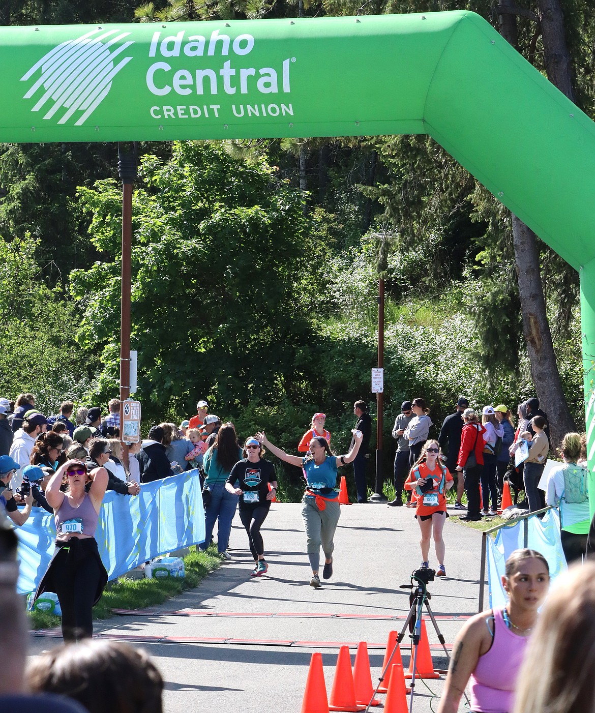 A runner raises her arms as she nears the finish line Sunday.