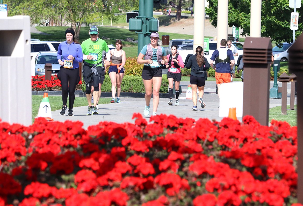 Runners make their way past the red geraniums at The Coeur d'Alene Resort on Sunday.
