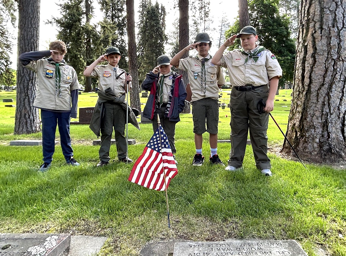 Members of Coeur d'Alene Boy Scout Troop 3 salute after placing a flag at the gravesite of a veteran at Forest Cemetery on Saturday in preparation for Memorial Day. From left, Blake Kroiss, Brad Stevens, Ian Frengle, Kai Owns and Ethan Schlegel.