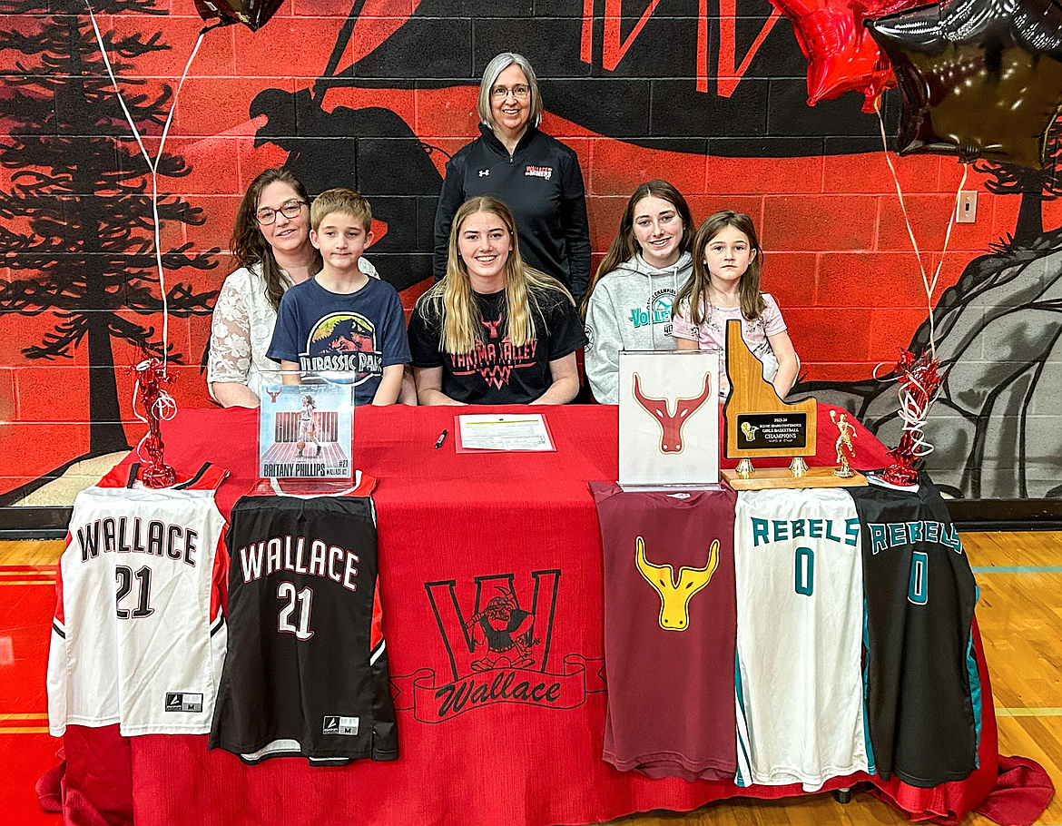 Wallace's Britany Phillips, pictured here  with her family and coach Nichole Farkas, recently signed with Yakima Valley College to play basketball.